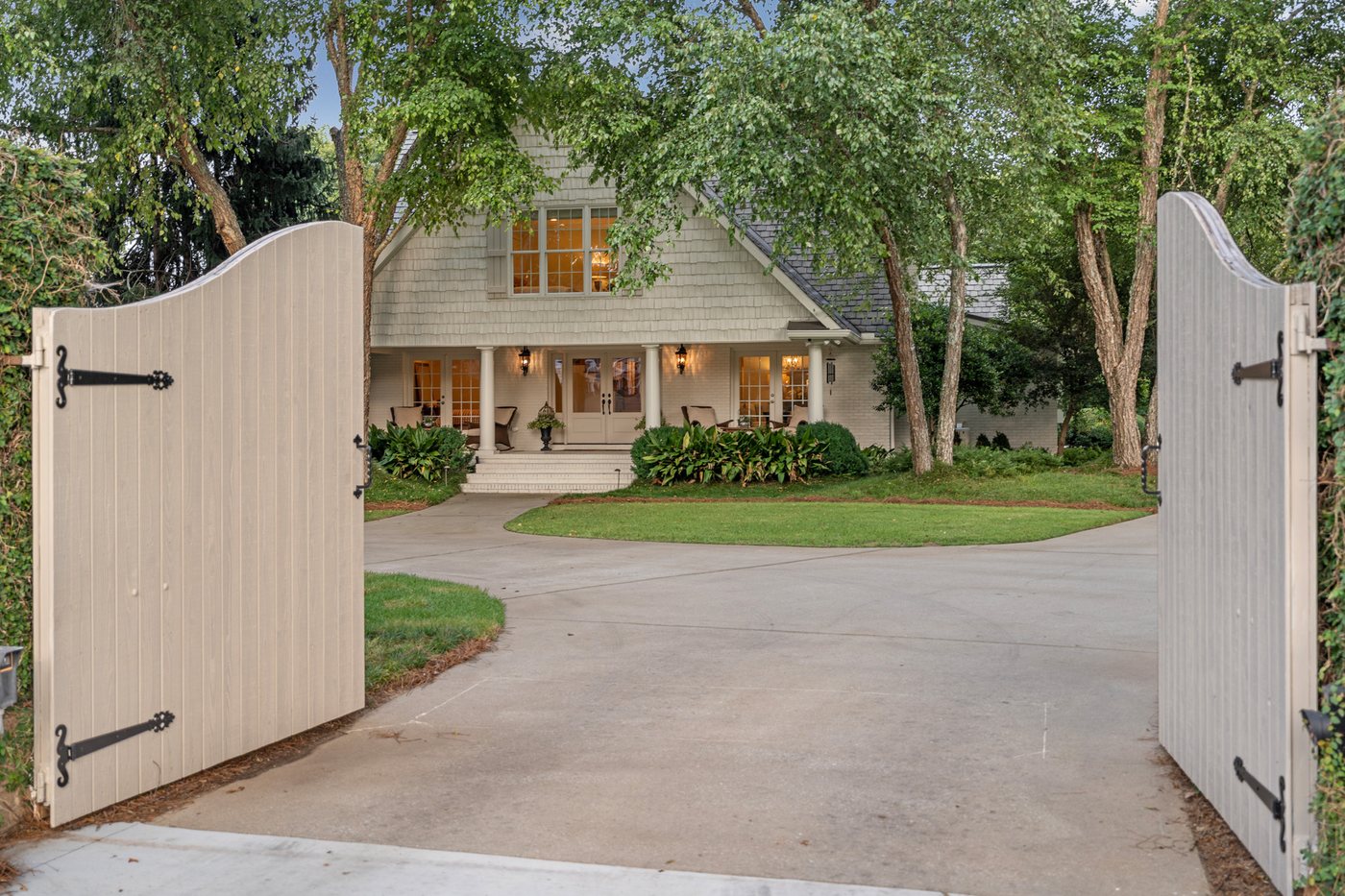 The motorized gates open to the house beyond